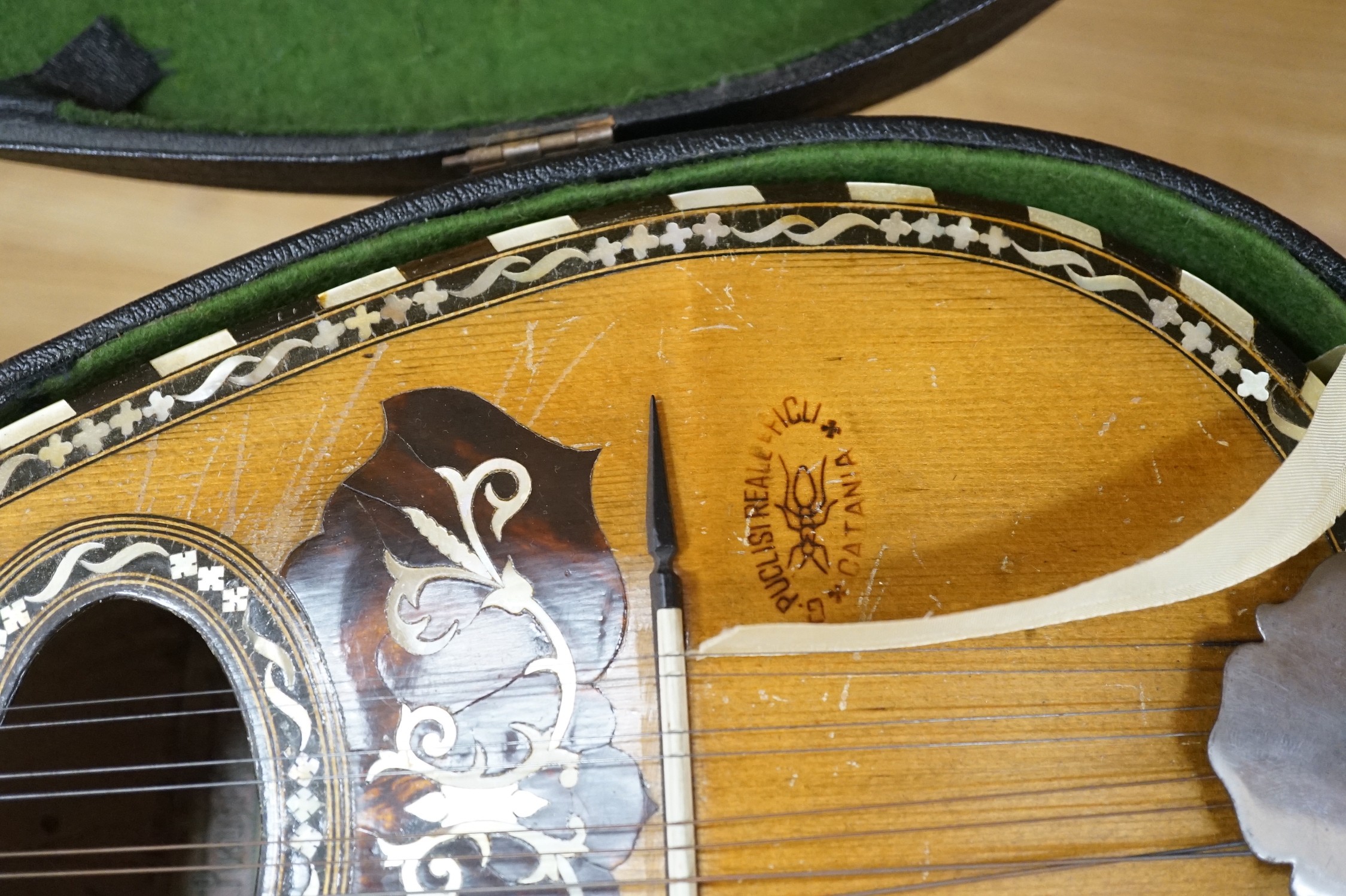 A cased late 19th/early 20th century Italian lute back mandolin with segmented rosewood back and spruce top, eight brass and bone pegs, 60.5cms high